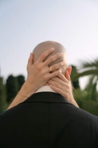 Braut legt dem Bräutigam zärtlich die Hände an den Kopf im warmen Abendlicht