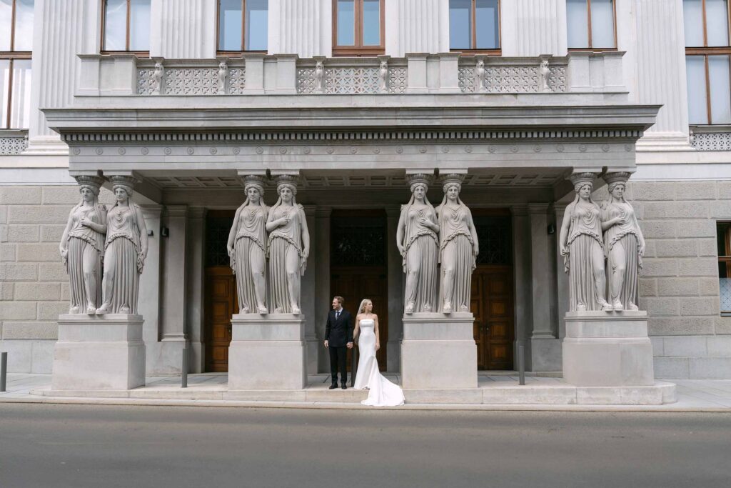 Brautpaar zwischen den monumentalen Säulen des Österreichisches Parlament in Wien
